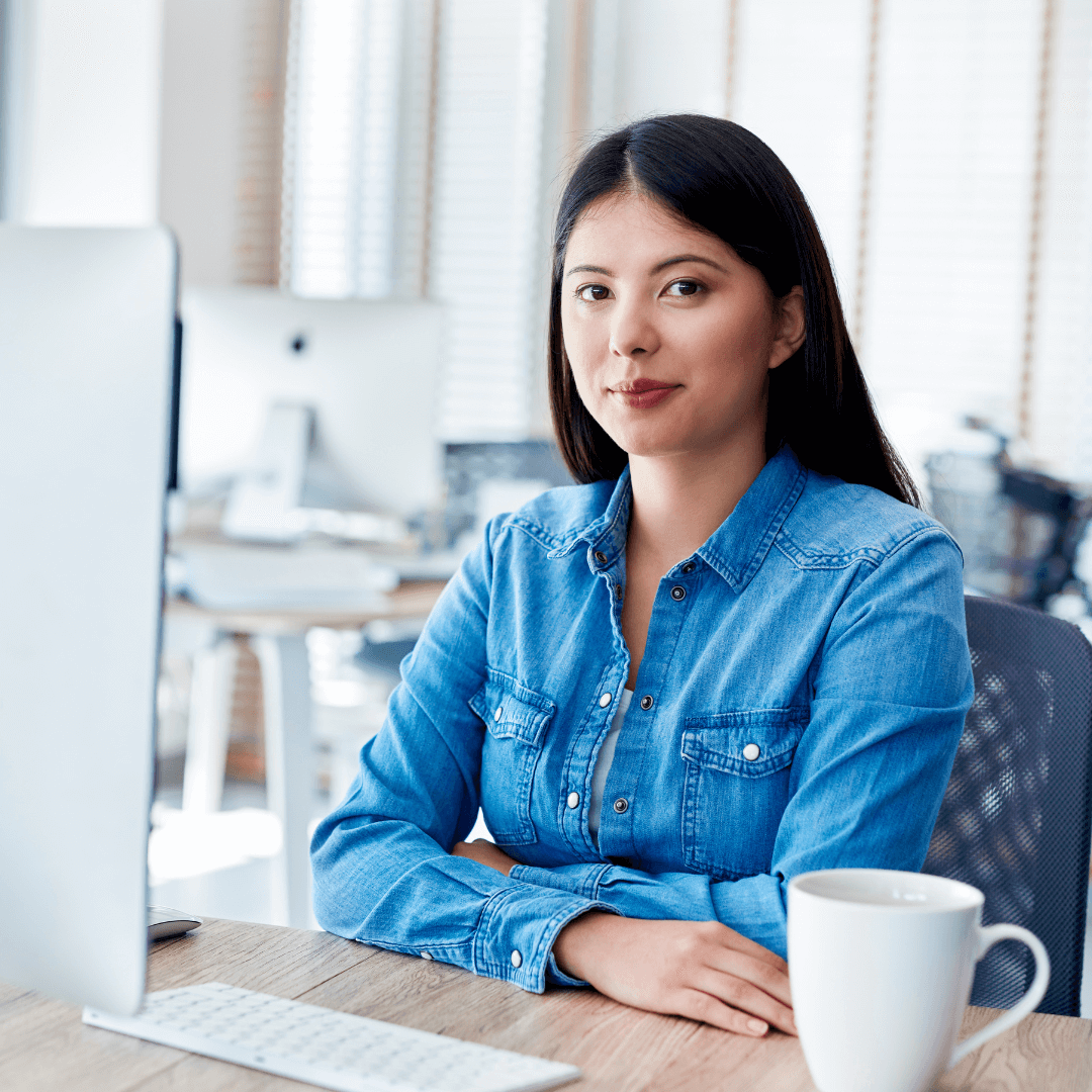 woman sitting at a desk with a mug next to her